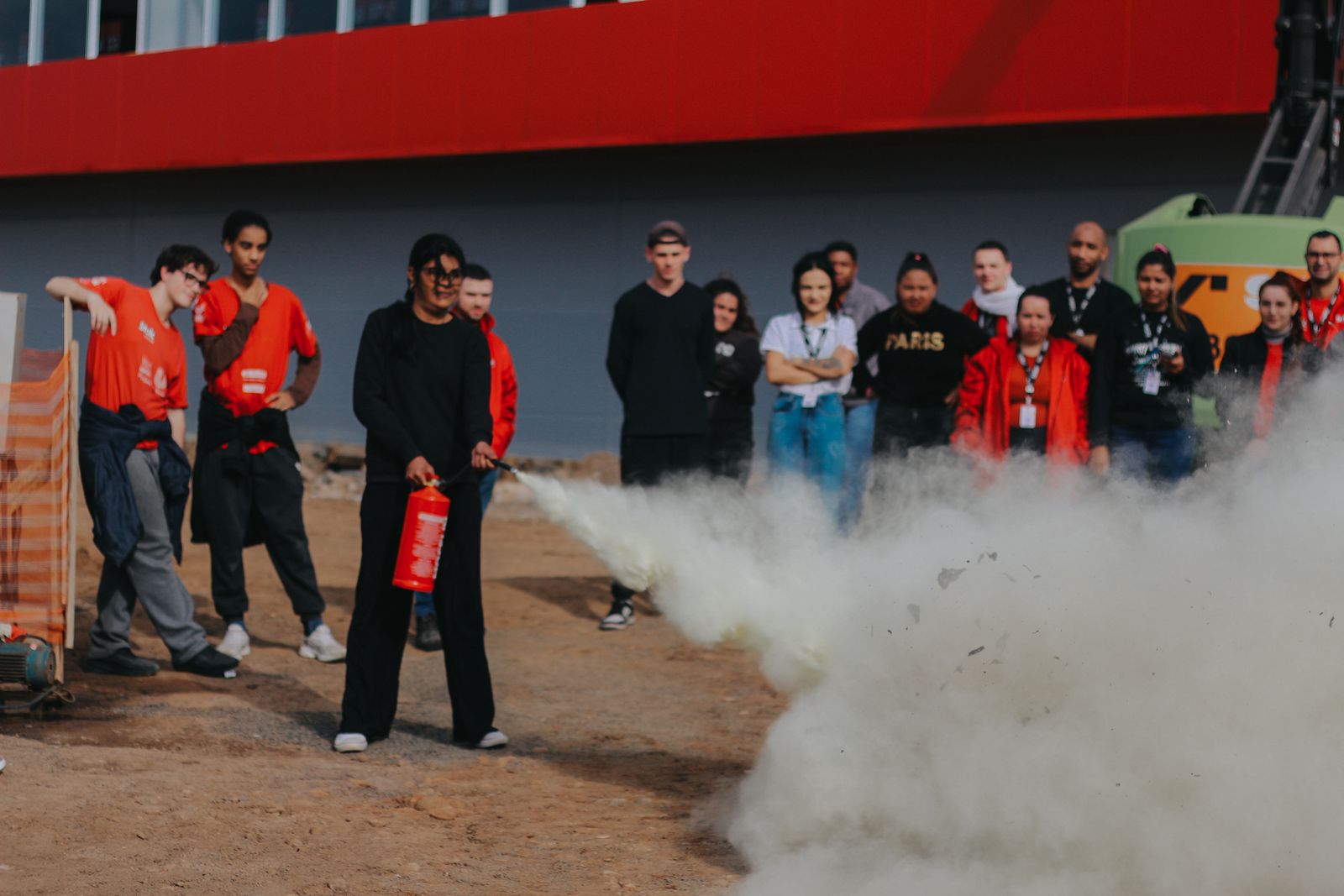 Participante do treinamento usando o extintor para apagar o fogo
